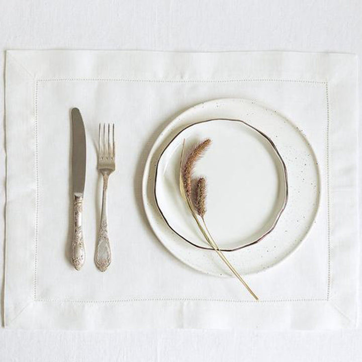White hemstitched napkin under a plate and cutlery